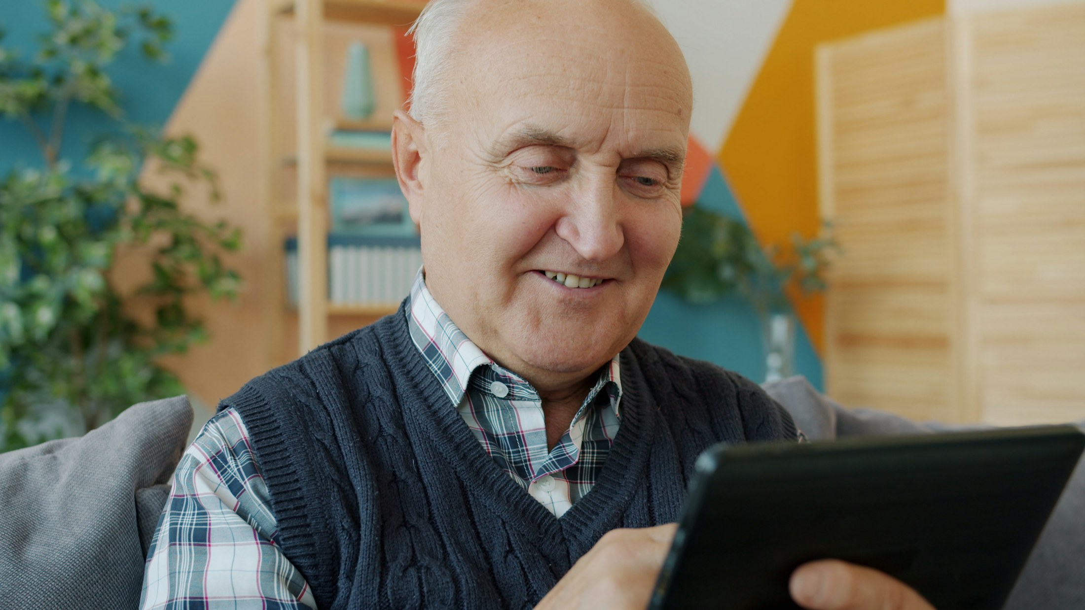 An older adult using a tablet at home